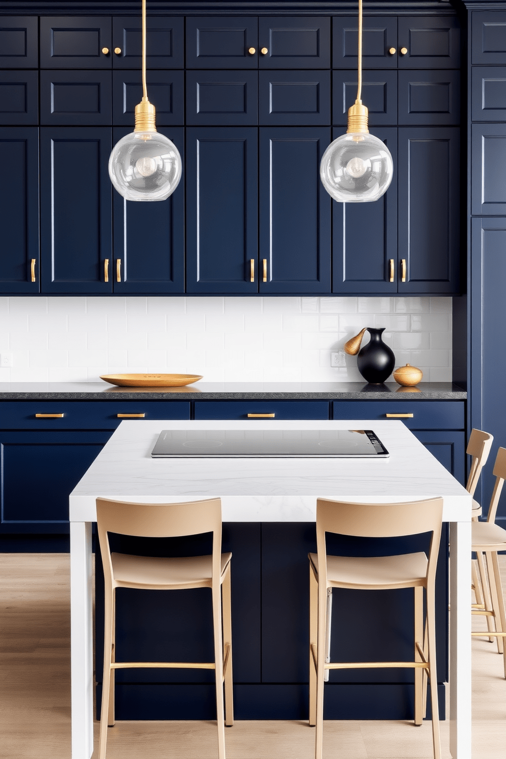 A modern kitchen island features an integrated stovetop seamlessly blending into the countertop. Surrounding the island are sleek bar stools with a minimalist design, and pendant lights hang above, providing warm illumination. The cabinetry is a rich navy blue, complemented by brass hardware that adds a touch of elegance. The backsplash is a glossy white subway tile, creating a striking contrast with the darker elements of the kitchen.